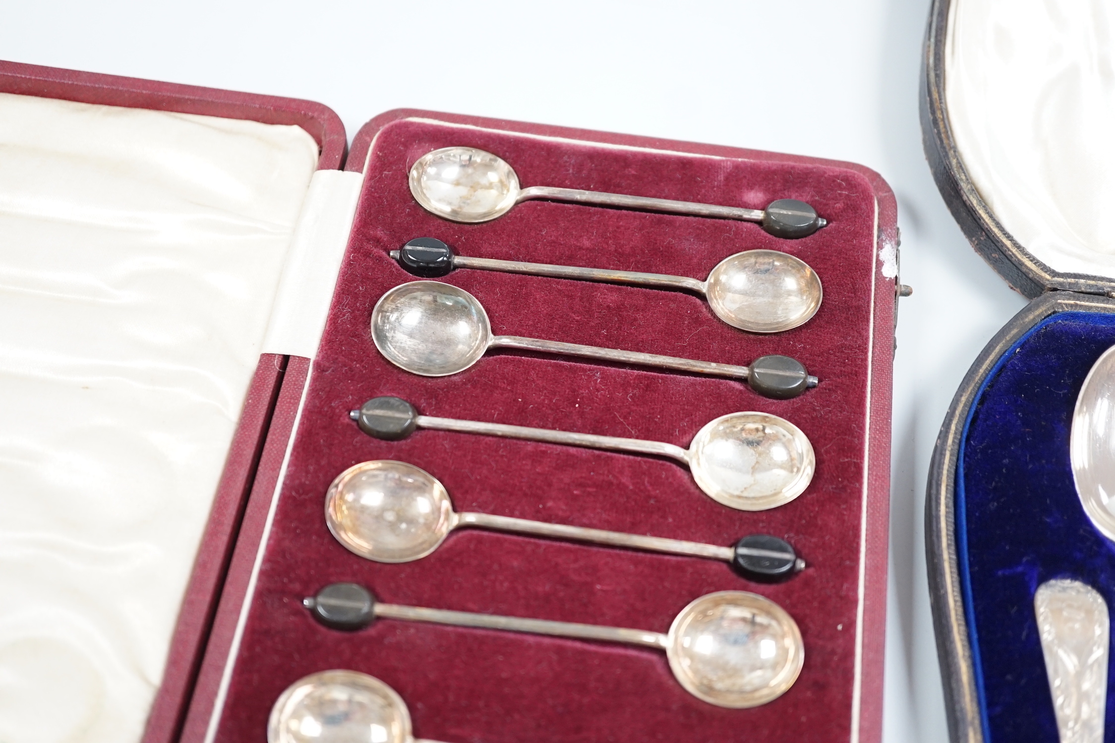 A cased set of twelve Edwardian Scottish silver teaspoons with sugar tongs, Lawson & Co, Glasgow, 1904 and a cased set of twelve sterling bean end coffee spoons, by Alexander Clark Co. Shanghai.